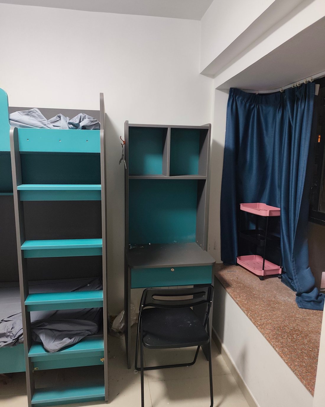 刚搬进来的宿舍：上下铺、书桌与蓝色窗帘